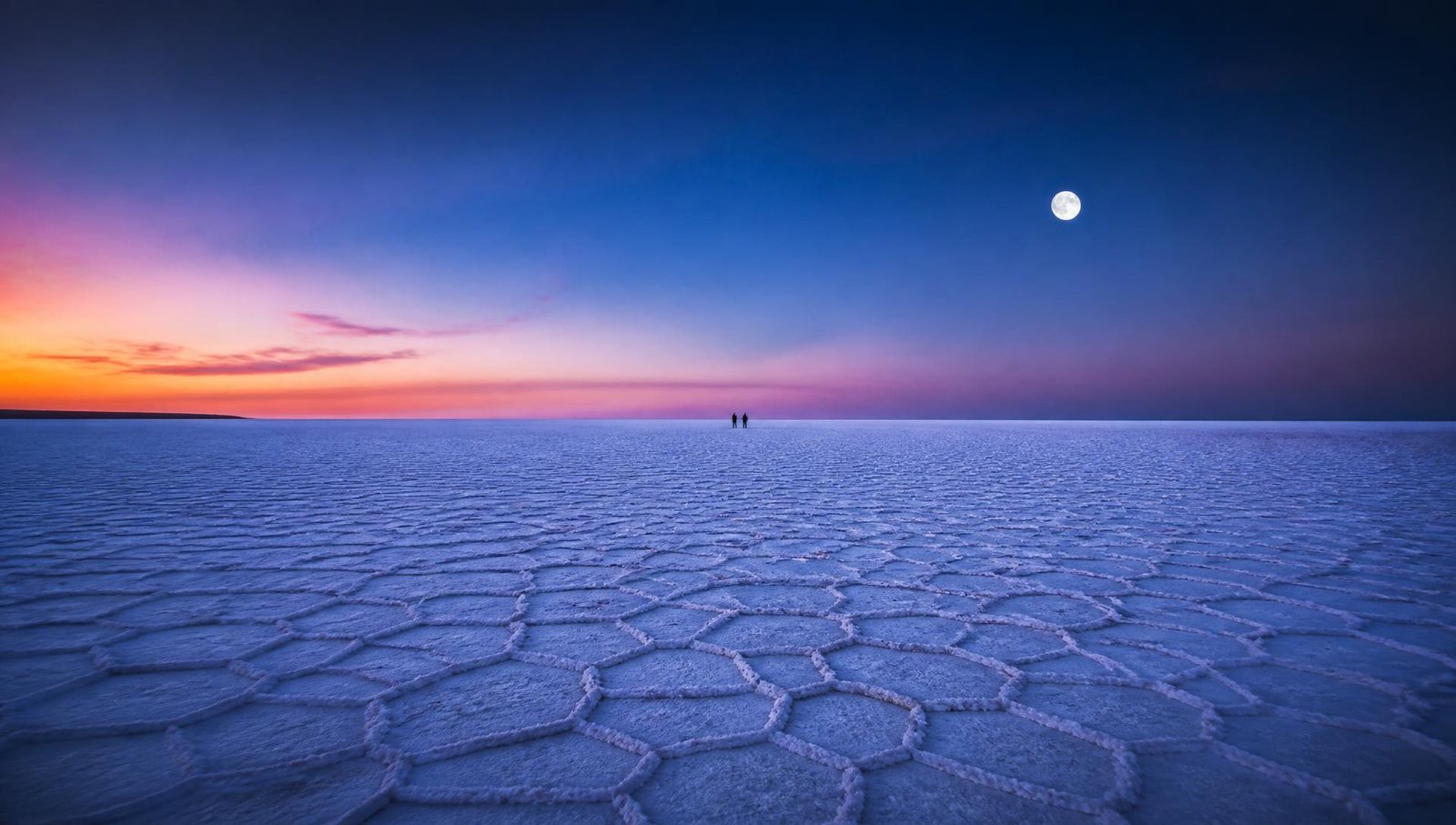 Travellers on the white salt flats of the Rann of Kutch at dusk