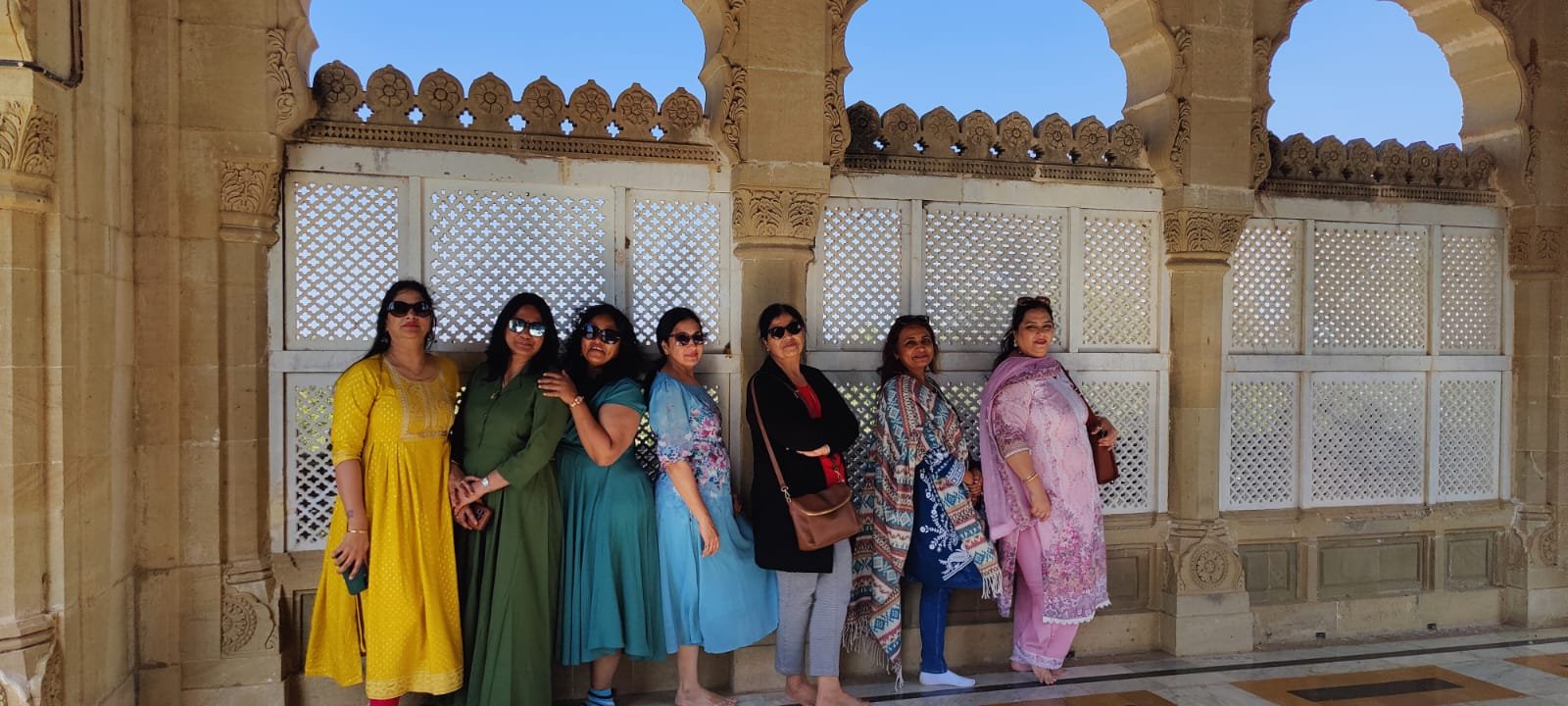 Tourists inside historical carved stone palace pavilions in Kutch